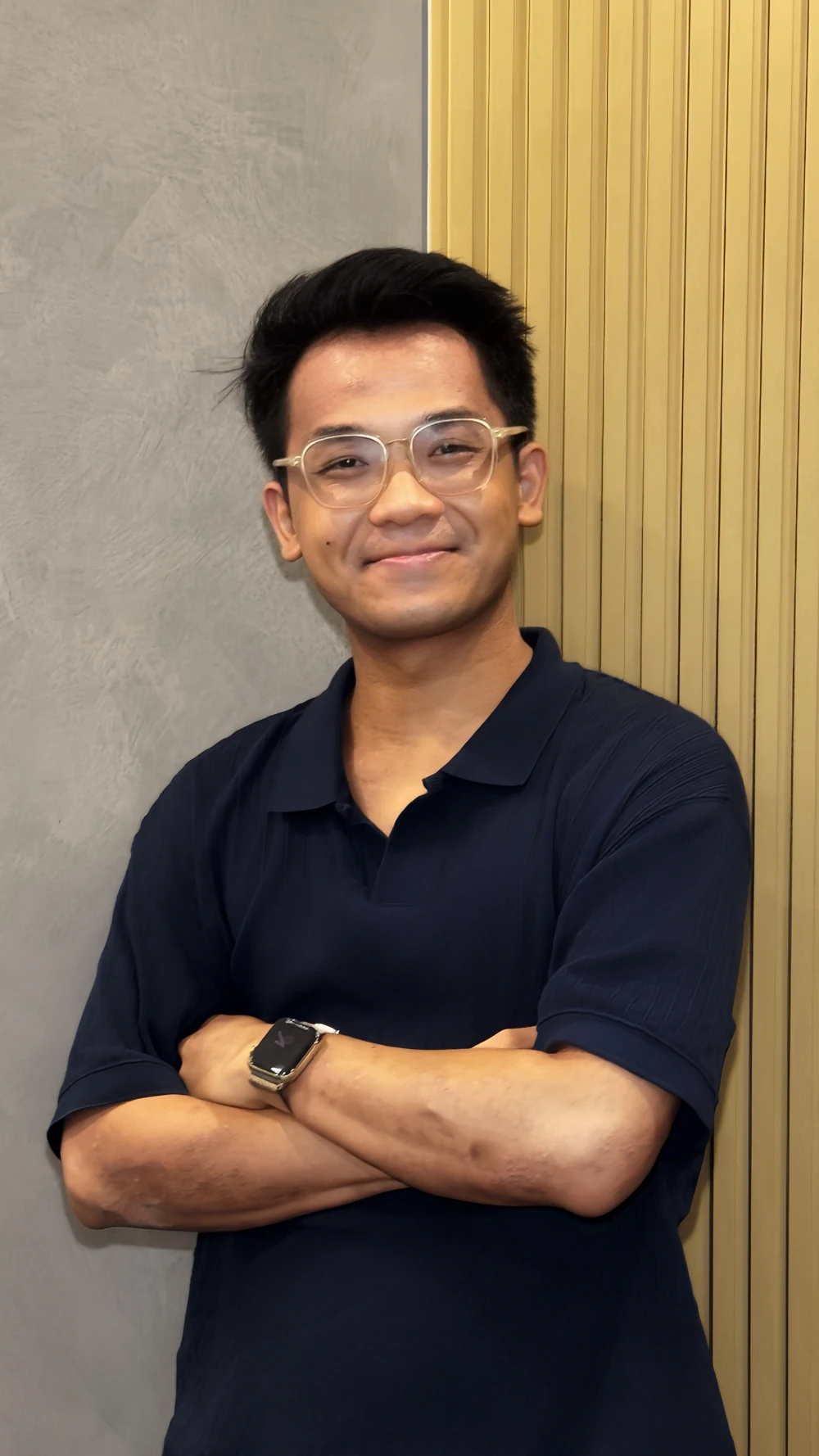 Zin in a navy polo shirt, standing with his arms folded